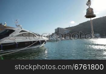 Bell in emergency on a background of yachts