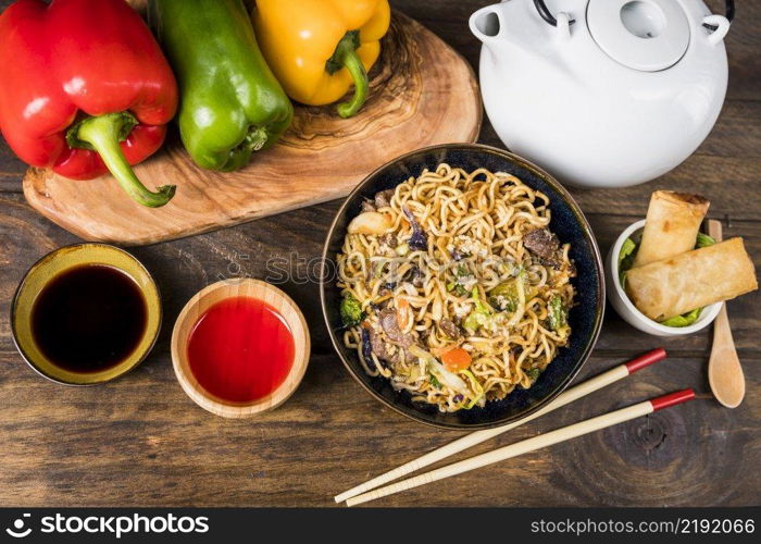 bell peppers udon noodles sauces spring rolls white desk