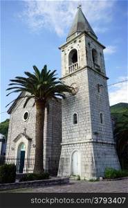 Bell tower and small stone church in Tivat, Montenegro