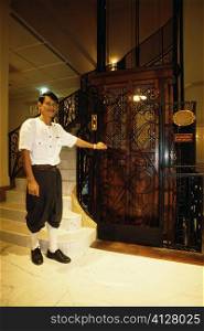 Bellhop standing near an elevator, Grand Hotel D&acute;angkor, Siem Reap, Cambodia