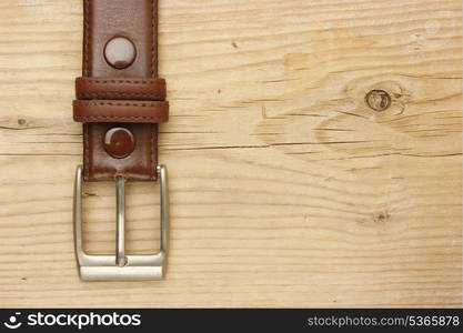 belt with a buckle on a wooden board