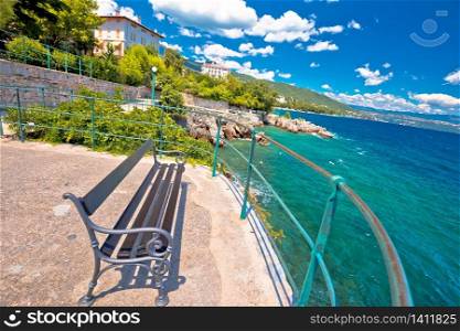 Bench by the sea on Lungomare walkway in town of Lovran, Opatija riviera, Kvarner bay of Croatia
