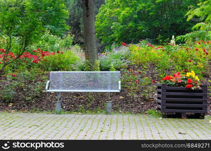 bench for relaxing in the summer park and flowers