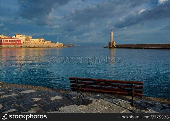 Bench in picturesque old port of Chania is one of landmarks and tourist destinations of Crete island in the morning on sunrise. Chania, Crete, Greece. Picturesque old port of Chania, Crete island. Greece