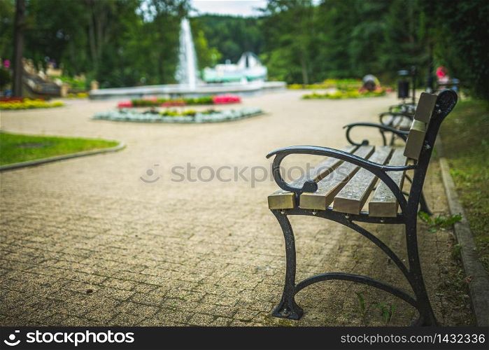 Bench in the park next to water fountain. Rest concept. Bench in the park next to water fountain.