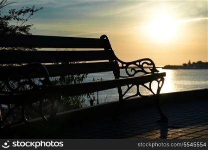 Bench near the sea against beautiful sunset