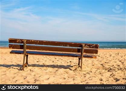 bench on a lonesome beach of the Baltic Sea with blue sky