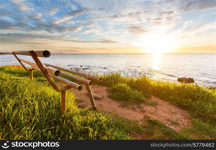 bench on sea coast at sunrice