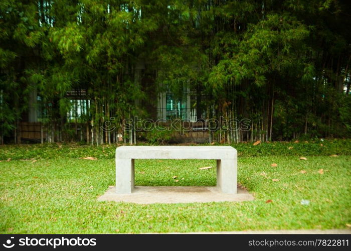 Bench seats and bamboo. Chair on the lawn green. Within the park.