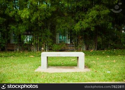 Bench seats and bamboo. Chair on the lawn green. Within the park.