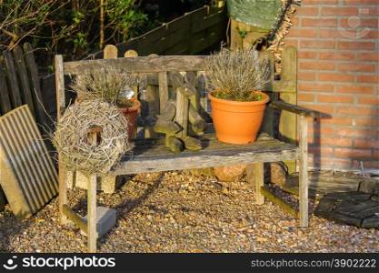 Bench with flower pots, figure of rabbit and a wreath decorated Dutch house