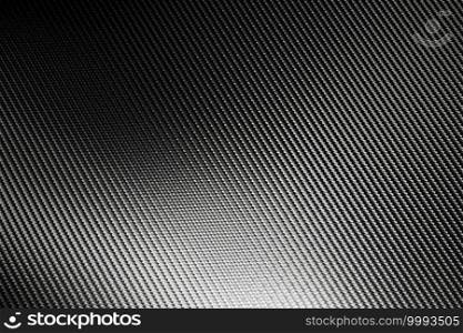 Bended surface of grey woven carbon fibre composite sheet. Texture and pattern background. Modern technology and material concept.