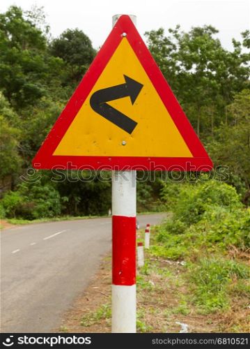 Bending roadtraffic sign on a road in the south of Vietnam