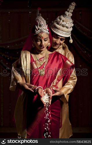 Bengali bride and groom making an offering