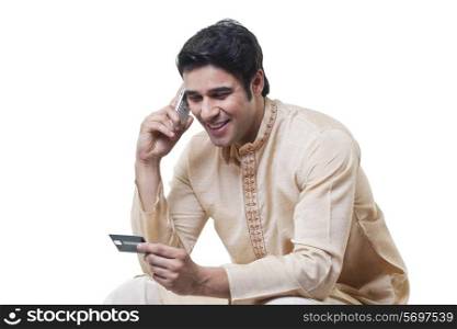 Bengali man paying by credit card on mobile phone