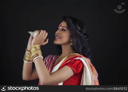Bengali woman holding a conch shell