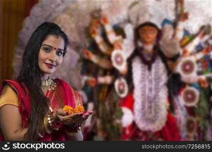 Bengali woman holding a flowers at Durga Puja