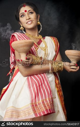 Bengali woman holding dhunuchis