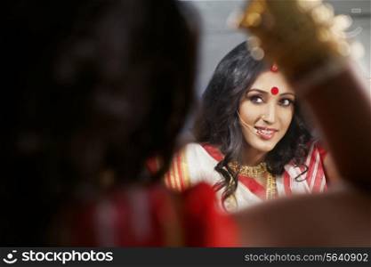 Bengali woman looking at herself in the mirror