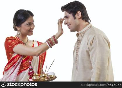 Bengali woman putting tika on man&rsquo;s head