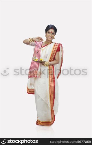 Bengali woman with puja thali smiling