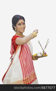 Bengali woman with puja thali smiling