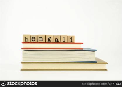 bengali word on wood stamps stack on books, conversation and translation concept