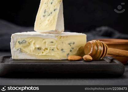 bergader blue cheese on a black wooden board, delicious snack
