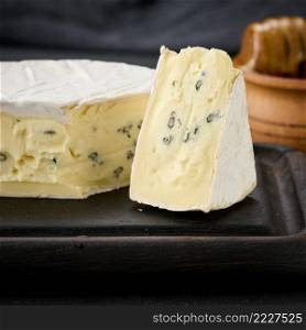 bergader blue cheese on a brown wooden board, delicious snack