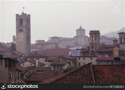 Bergamo bell tower and house roofs in fog&#xA;
