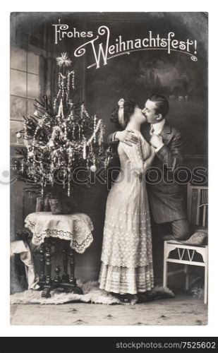 BERLIN, GERMANY - CIRCA 1911: rare antique german postcard showing young couple celebrated with christmas tree. Vintage picture from ca. 1911, in Berlin, Germany