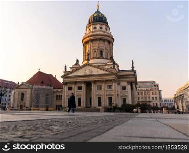 Berlin, Germany - March 28, 2020 - French Cathedral located at the Gendarmenmarkt at the Corona crisis - A lonely man