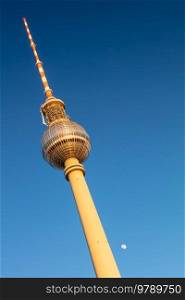 Berlin Television Tower, Berliner Fernsehturm and Moon in golden evening sunshine against a blue sky, Berlin, Germany