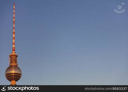 Berlin Television Tower, Berliner Fernsehturm bathed in warm golden evening sunshine against a blue sky, Berlin, Germany