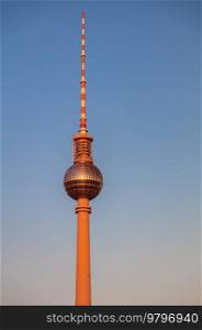 Berlin Television Tower, Berliner Fernsehturm bathed in warm golden evening sunshine against a blue sky, Berlin, Germany
