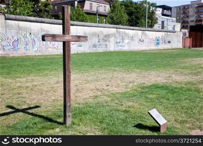 Berlin Wall Memorial with graffiti and cross commemorating the deaths and division. The Gedenkstatte Berliner Mauer