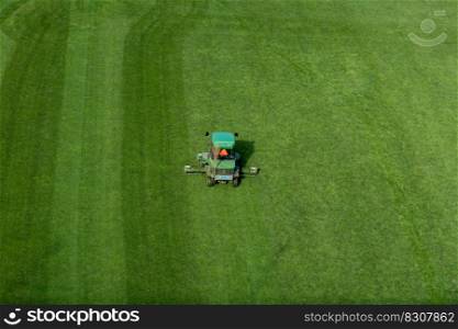 Bern, Switzerland - 26 April, 2021  a ride on lawn mower cutting grass on a football field