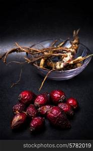 berries are dried rose hips and herbs on black background. rose hips
