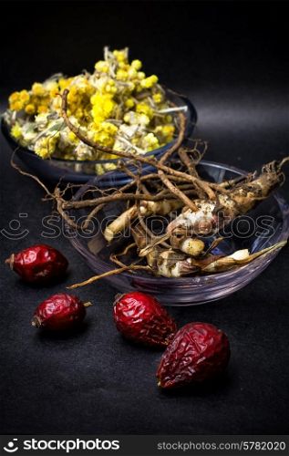 berries are dried rose hips and herbs on black background.Selective focus. rose hips and folk medicine