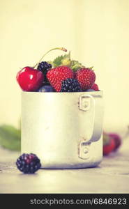 Berries in a rustic mug on a table