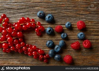 Berries mix on wooden board blueberries red currants and raspberries