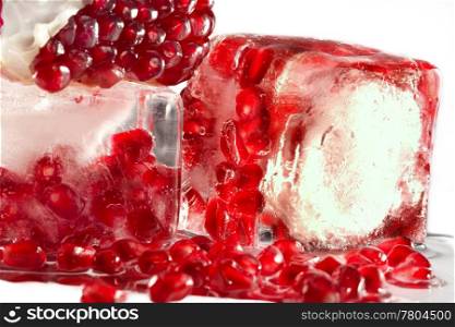 Berries of a ripe pomegranate in ice on a white background.