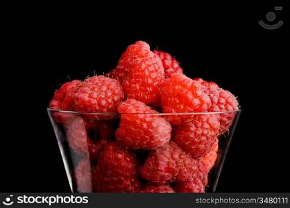 berries raspberries in a wineglass Isolated on black