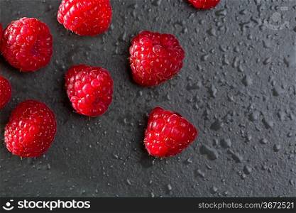 berries raspberry on black background macro closeup with fresh water drops