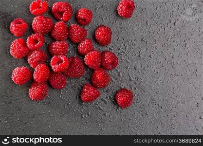 berries raspberry on black background macro closeup with fresh water drops