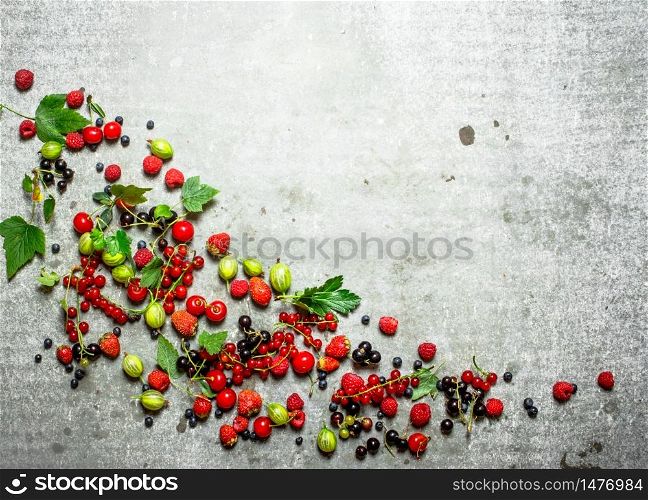 Berries with mint leaves on a stone background.. Berries with mint leaves on stone background.