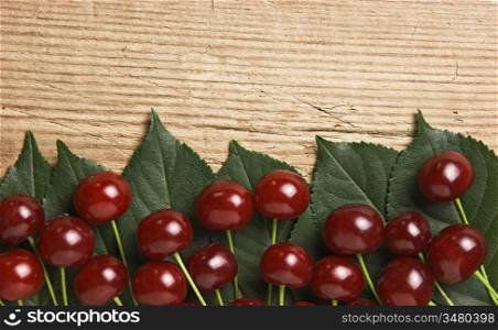 Berry Cherry with leaves on a wooden background