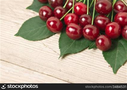 Berry Cherry with leaves on a wooden background
