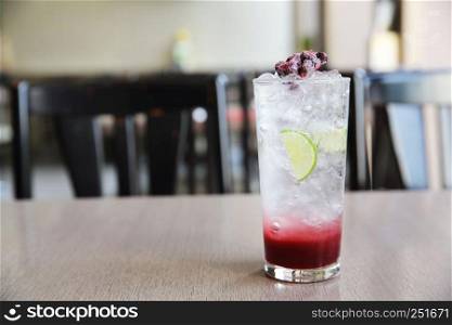 Berry cocktail with lime on wood background