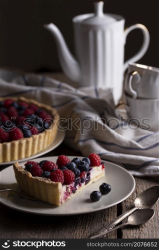 berry pie with raspberries and blueberries on the background of retro cups and teapot
